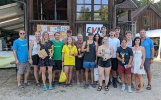 Siegerehrung mit Pokalen und Preisträgern vor Holzhäusern in Österreich