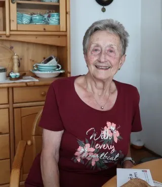 Elisabeth Steiner, Jubilarin, lächelt in ihrem Wohnzimmer in Oberösterreich.