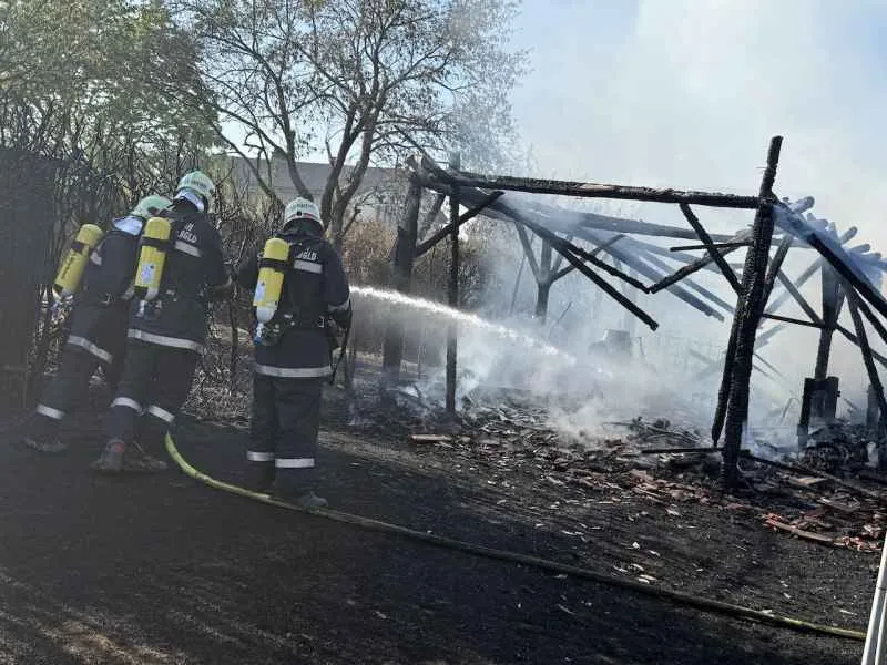 Feuerwehrleute löschen einen brennenden Schuppen in Niederösterreich mit Löschwasser.