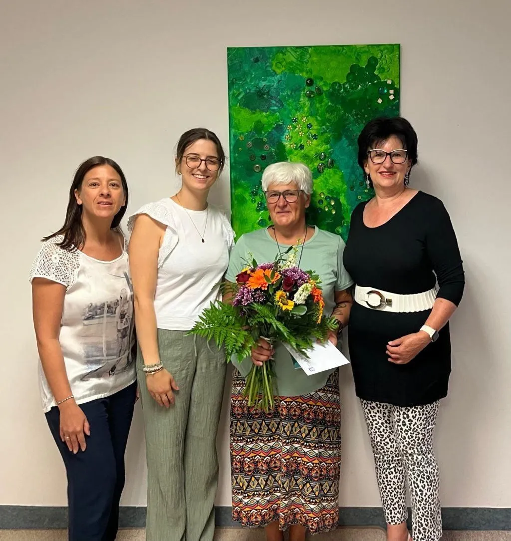 Vier Frauen mit Blumenstrauß vor einem grünen Gemälde in Österreich