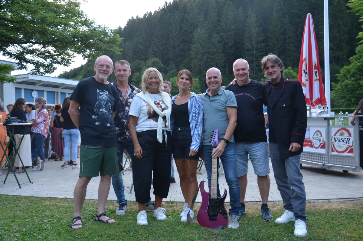 Bandmitglieder mit E-Gitarre vor Kaiser-Schirmen
