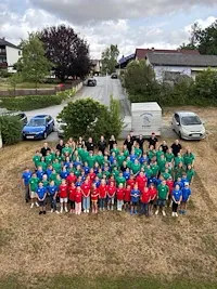 Fußballjugend des SV Schattendorf in Rot, Grün und Blau vor einem Gebäude in Schattendorf