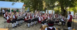 Blasmusik spielt vor einem Festzelt in Österreich, Musiker in Tracht spielen Instrumente