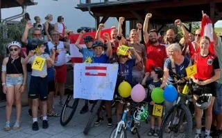 Radfahrer mit österreichischen Fahnen jubeln in der Steiermark.