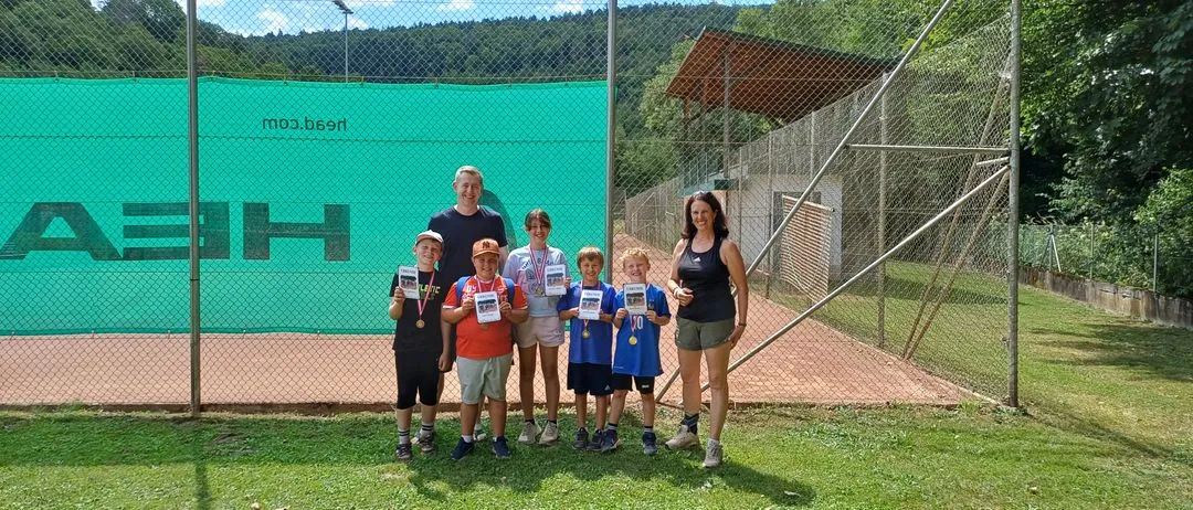 Tennis-Kinder mit Urkunden und Medaillen auf einem Tennisplatz in Österreich