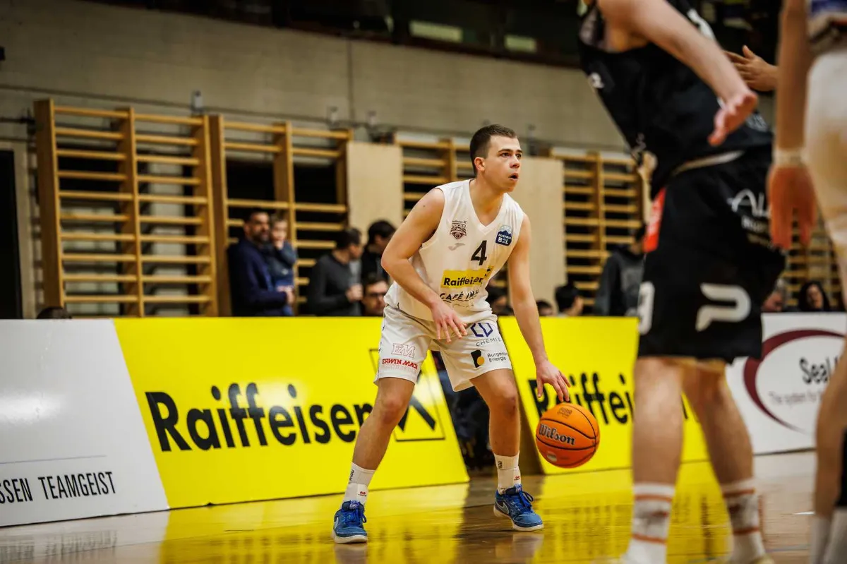 Basketballspieler mit Ball in der Hand in einer Sporthalle in Österreich