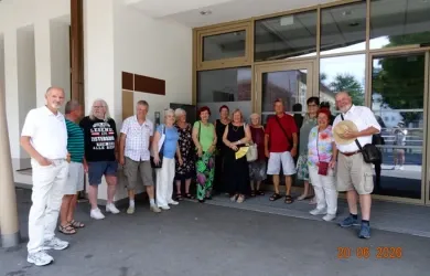 Gruppe von Männern und Frauen steht vor einem Gebäude in Österreich