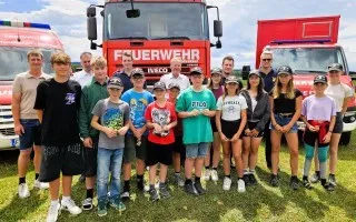 Jugendfeuerwehr Steyr-Land mit Kommandant und Einsatzfahrzeugen vor dem Feuerwehrhaus