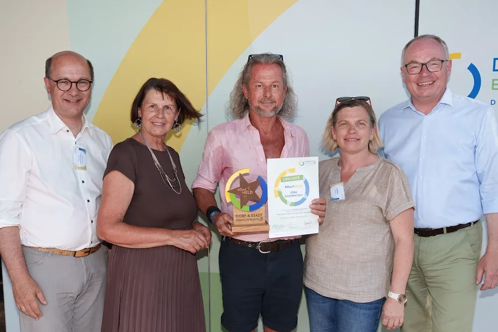 Jörg Zahornitzky mit Urkunde und Dorf-Held-Auszeichnung bei Dorf & Stadt Erneuerung