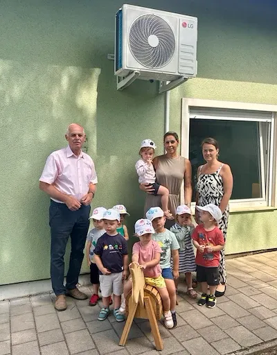 Kindergartenkinder mit Betreuerinnen und einem Mann vor einem Gebäude in Österreich