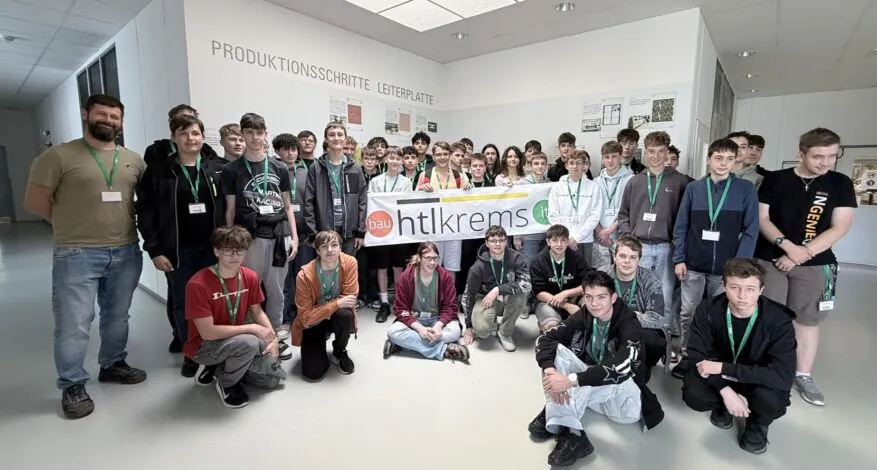 HTL Krems Schüler mit Banner vor Produktionsschritte-Leiterplatte