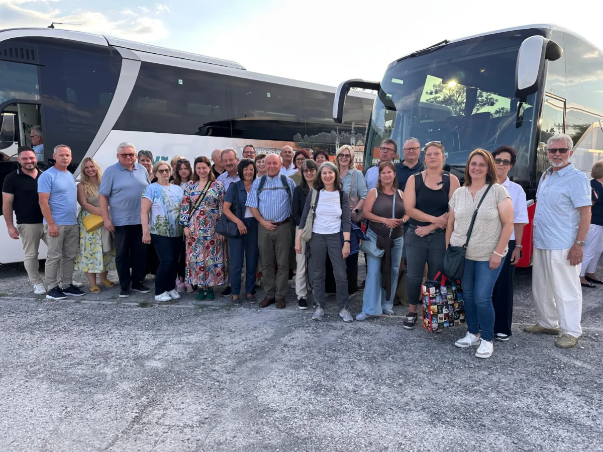 Reisegruppe vor zwei Reisebussen in Österreich