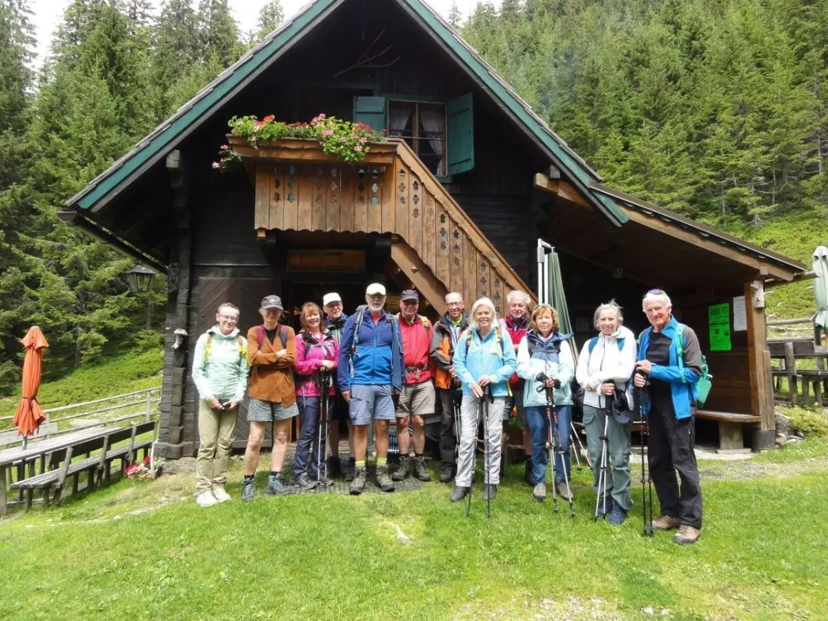 Wandergruppe vor einer Holzhütte in den Bergen, Österreich