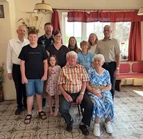 Familienfoto einer Großfamilie mit Großeltern im Vordergrund in einem hellen Raum