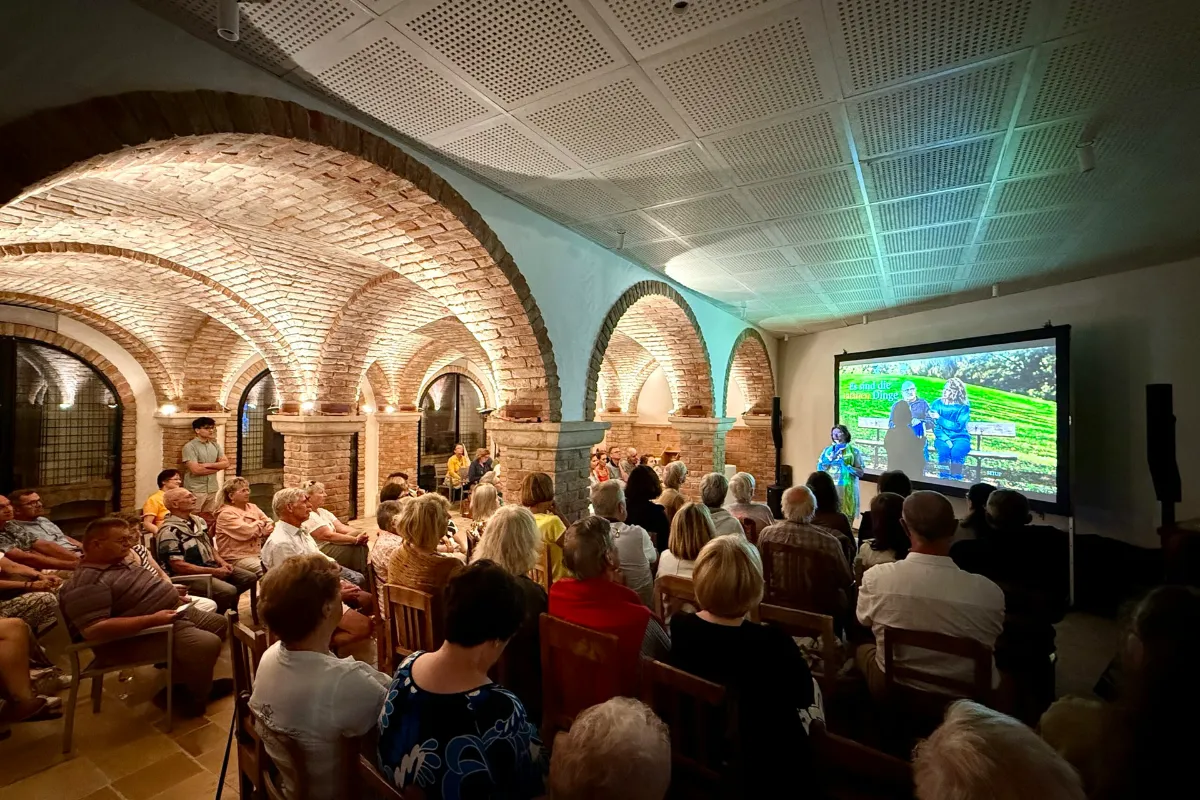 Vortragende mit Präsentation in historischem Kellergewölbe in Österreich