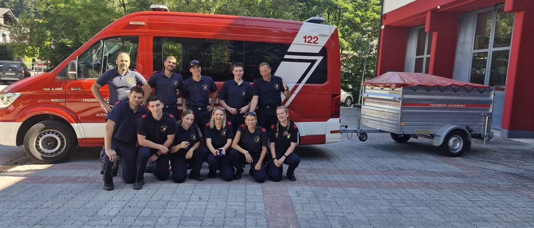 Feuerwehr Altenmarkt mit Einsatzfahrzeug und Anhänger vor dem Feuerwehrhaus