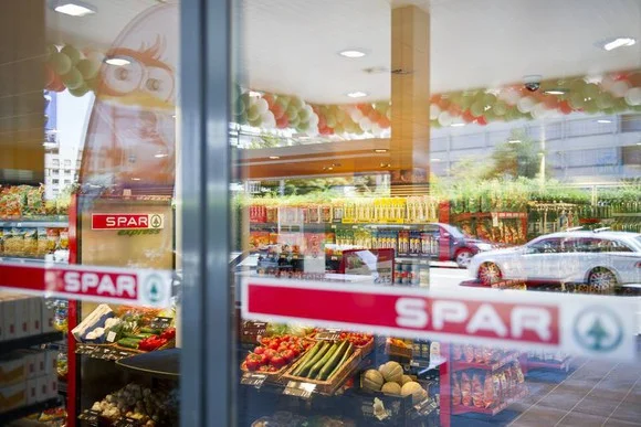 Spar Express in Österreich mit frischem Obst und Gemüse, Autos vor dem Geschäft