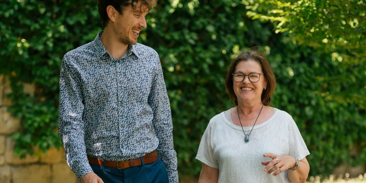Mann mit blauer Blumenhemd und Frau mit Brille lächeln im Garten