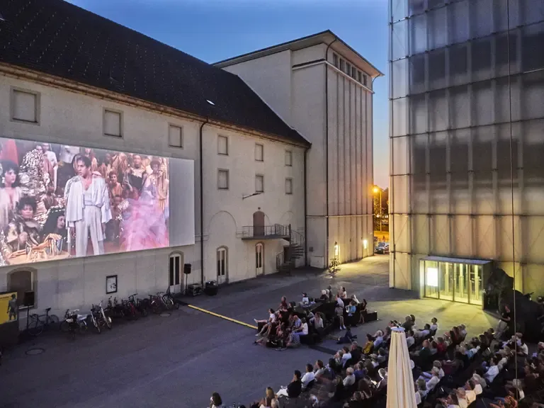 Open-Air-Kino in Österreich mit Menschenmenge, die auf Leinwand schaut