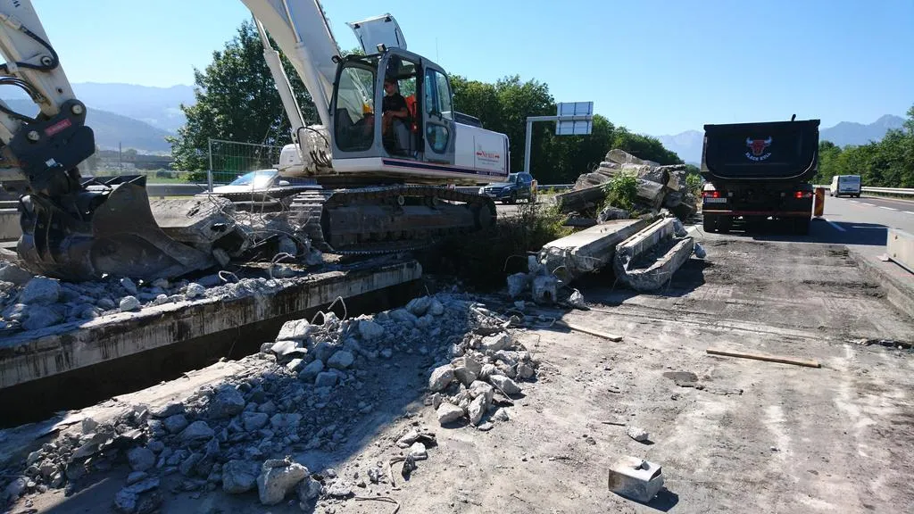 Bagger reißt Autobahnbrücke in Vorarlberg ein, Muldenkipper wartet auf Abtransport