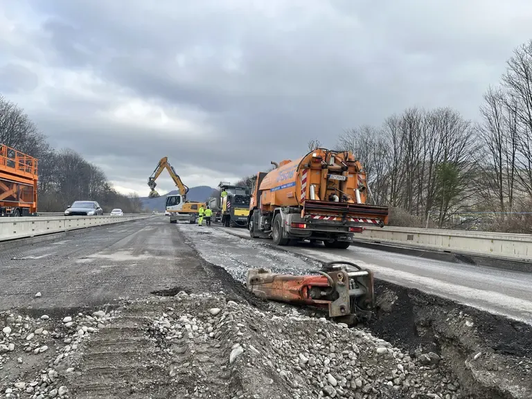 Straßenbauarbeiten mit Baggern und Lastwagen auf einer Autobahn in Österreich