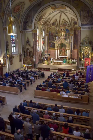 Gottesdienst in der Kirche mit Gläubigen, die auf Kirchenbänken sitzen