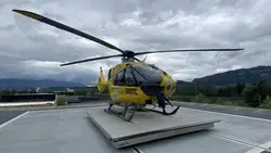 Christophorus 1 Hubschrauber am Landeplatz in Tirol mit Bergkulisse und Wolken