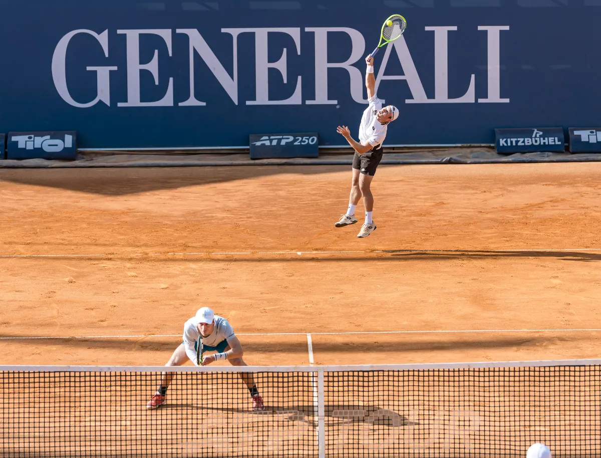 Tennisspieler beim Aufschlag und Return auf Sandplatz in Kitzbühel