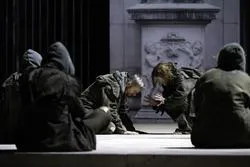 Schauspieler in düsterer Inszenierung mit Säule im Hintergrund