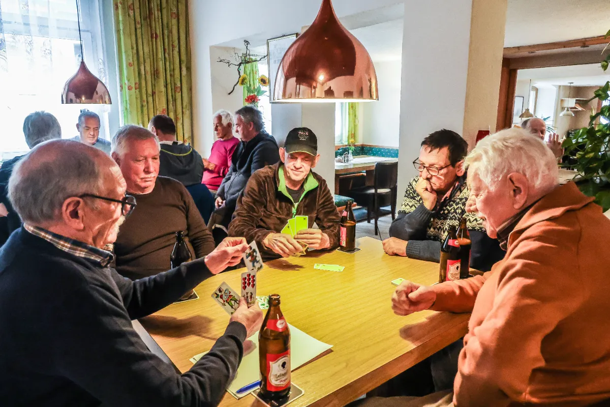 Herren spielen Karten in einem Gasthaus in Tirol