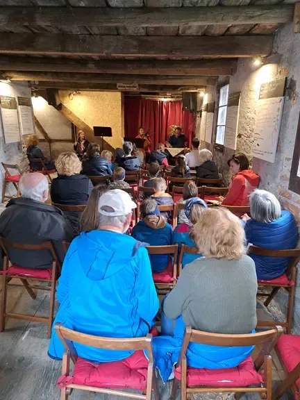 Konzert im historischen Gewölbe mit Publikum, Musiker spielen Cello und Geige