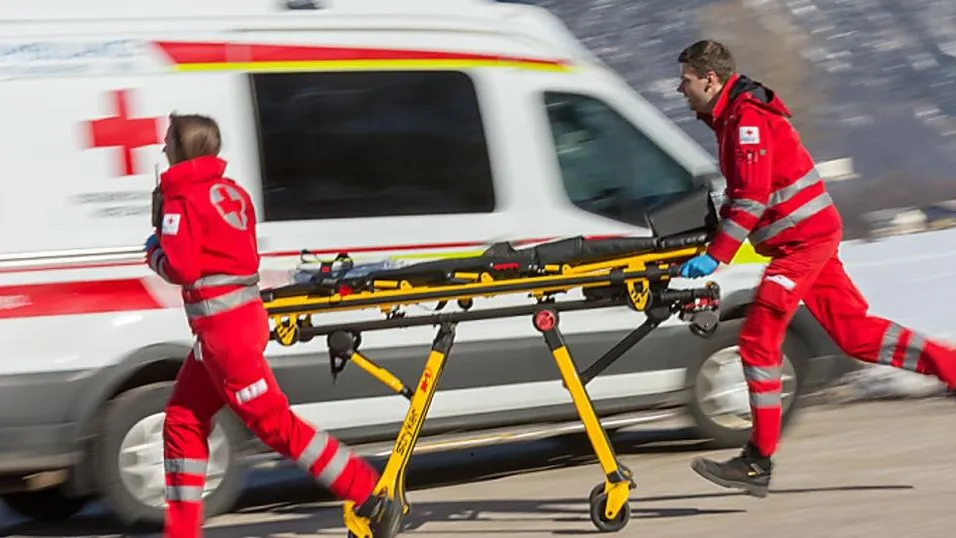 Rotes Kreuz Sanitäter mit Trage und Rettungswagen in Bewegung in den Bergen