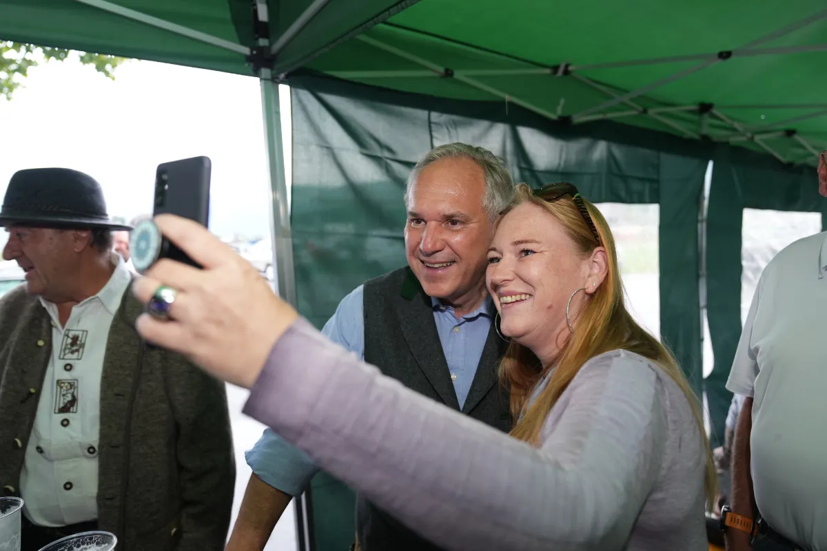 Landeshauptmann Markus Wallner macht Selfie mit Frau vor Zelt