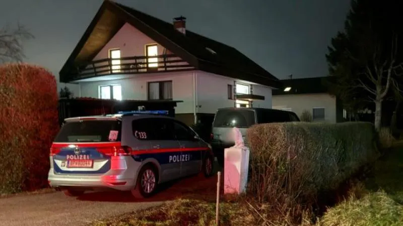 Polizeiauto und ein Haus in der Nacht, Einsatzkräfte vor Ort