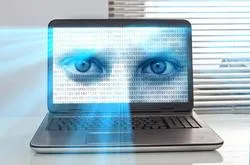 Laptop mit Augen und Binärcode auf dem Bildschirm als Symbol für Überwachung