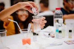 Kinder experimentieren im Chemieunterricht mit Flüssigkeiten in einem Labor in Wien.