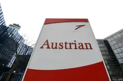 Austrian Airlines Logo auf einem Schild vor modernen Gebäuden in Wien.