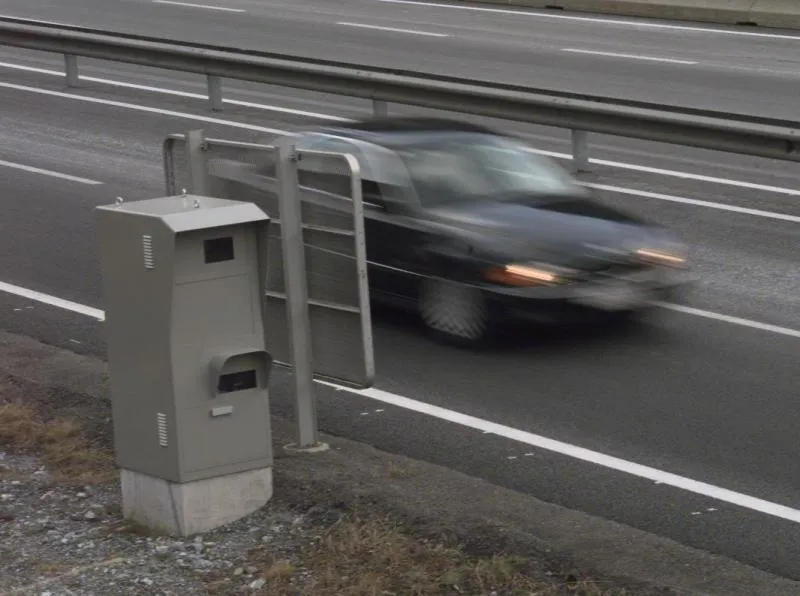 Blitzer auf Autobahn mit vorbeifahrendem Auto in Bewegung