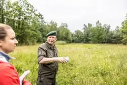 Bundesheer-Offizier erklärt im Feld bei Wien einer Frau die Lage.
