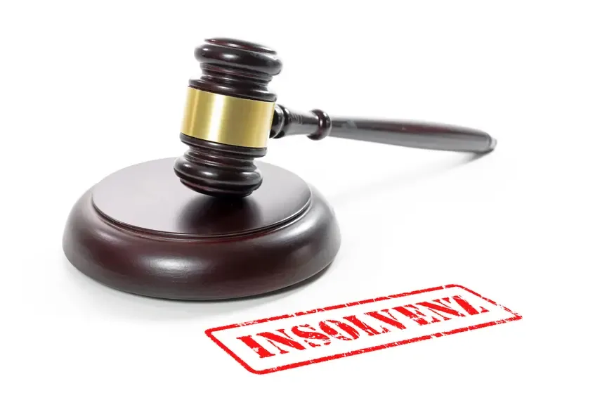Insolvenzstempel und Richthammel auf weißem Grund