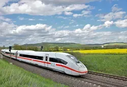 ICE-Zug fährt durch eine Landschaft mit Rapsfeld und blauen Wolken.