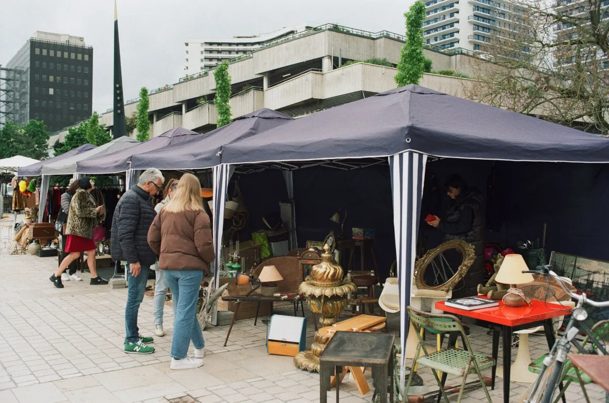 Flohmarkt in Wien: Besucher bestaunen Antiquitäten und Gebrauchtwaren unter Zelten.