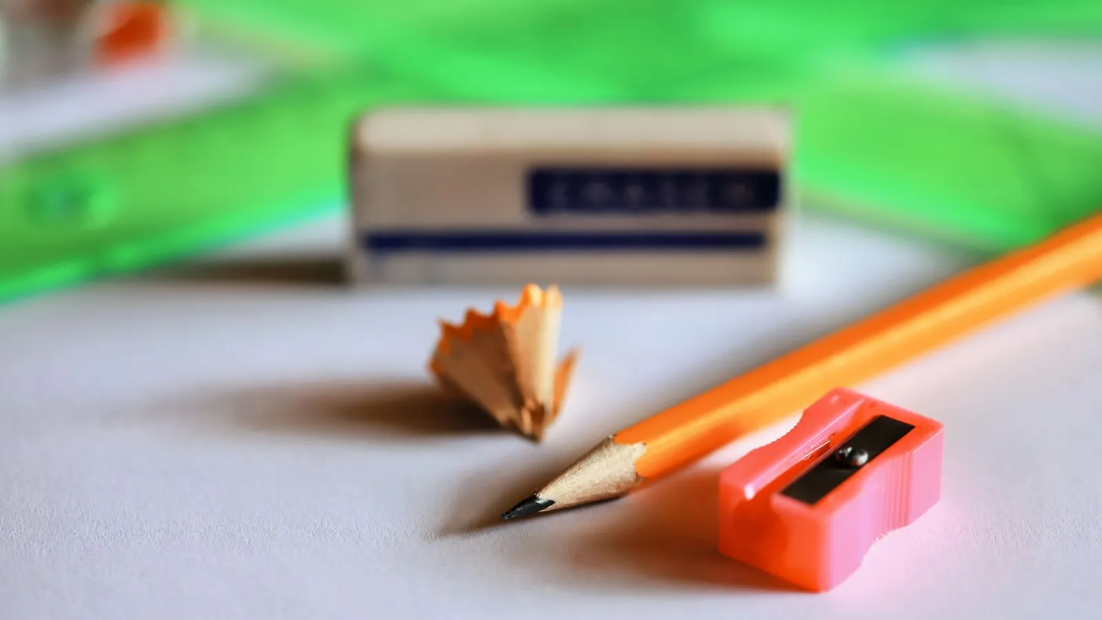 Bleistift mit Radiergummi, Spitzer und Schärfspänen auf weißem Untergrund