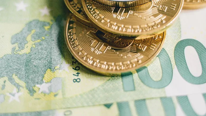 Bitcoin-Münzen liegen auf 100-Euro-Banknoten in Wien