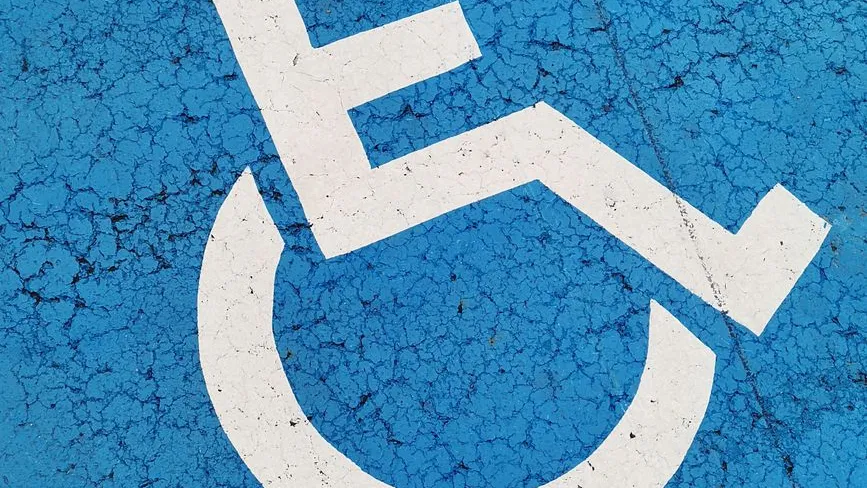 Behindertenparkplatz-Symbol auf blauem, rissigem Untergrund