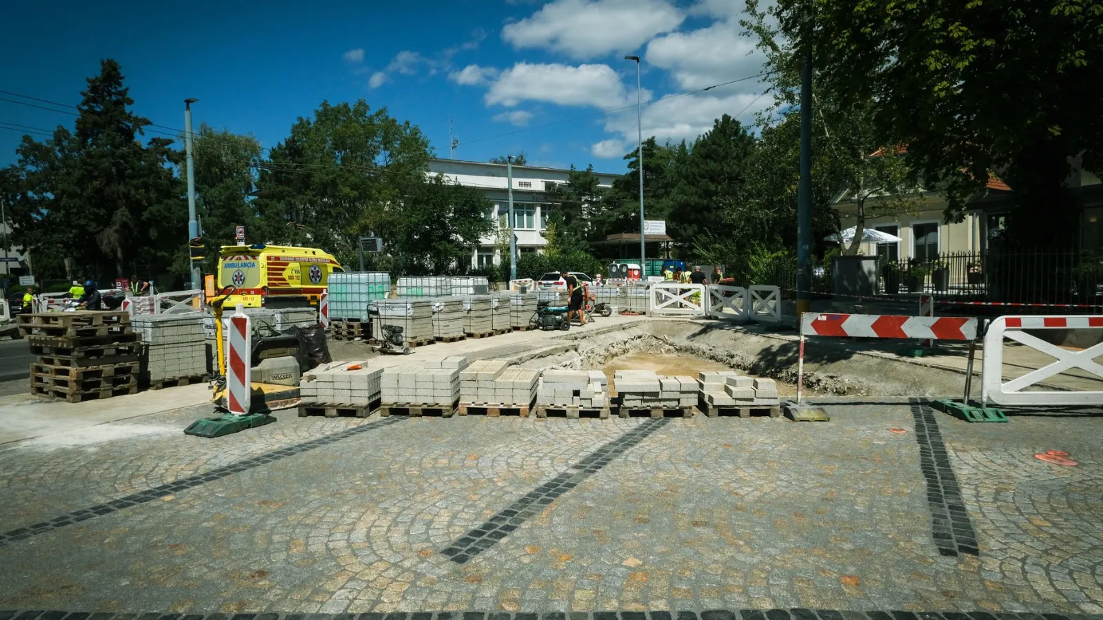Straßenbauarbeiten mit Absperrungen und einem Arbeiter in rotem T-Shirt in Österreich
