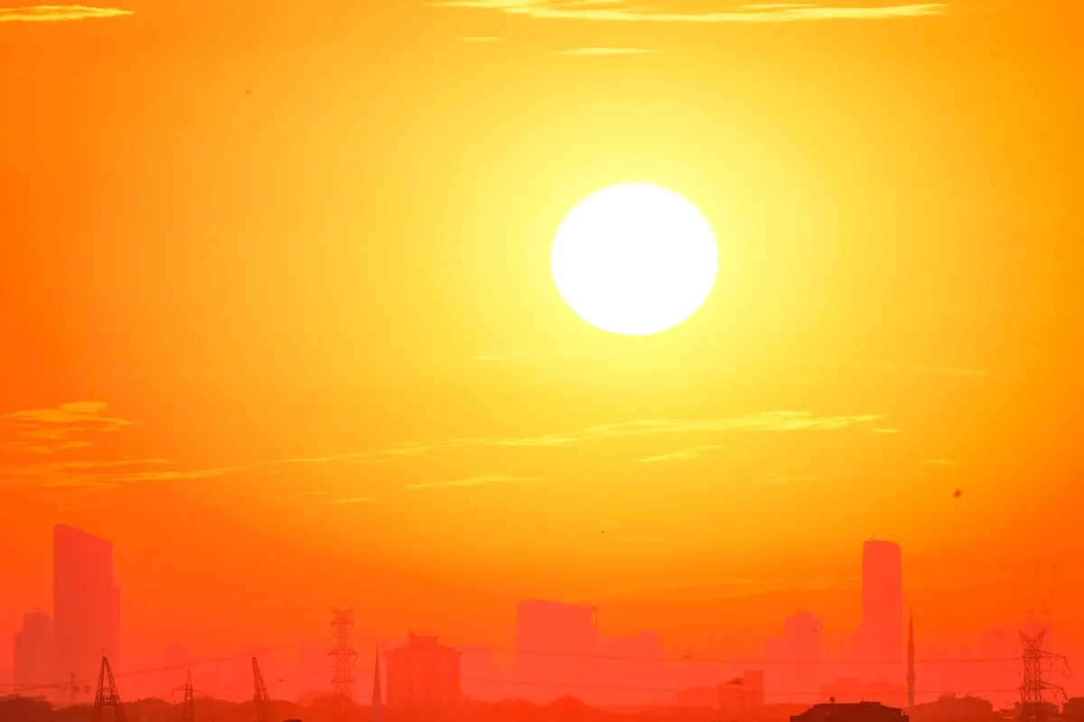 Sonne über Stadtkulisse bei Sonnenuntergang mit Hochhäusern und Strommasten