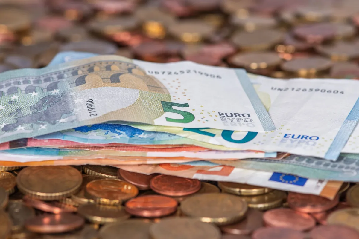 Euro-Scheine und Münzen liegen übereinander, Nahaufnahme.
