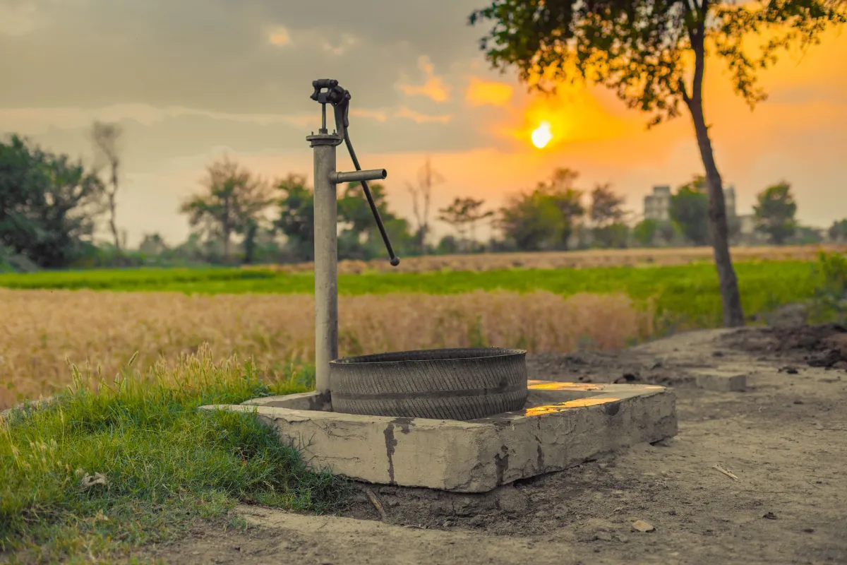 Wasserpumpe auf einem Feld in Indien bei Sonnenuntergang