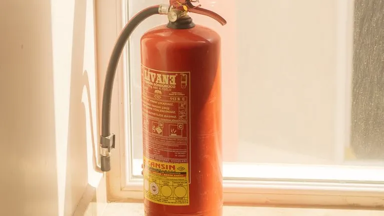 Feuerlöscher im Sonnenlicht neben einem Fenster